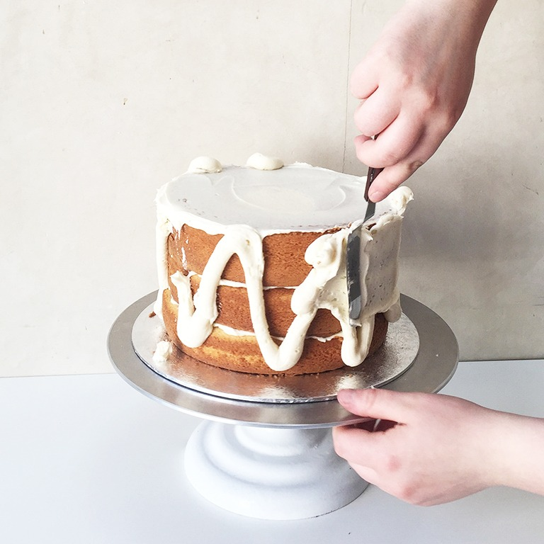 applying crumb coat to a cake