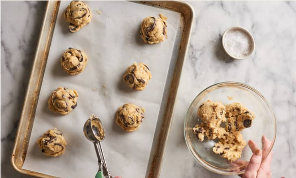 Scooping cake mix cookie dough onto parchment lined baking sheet