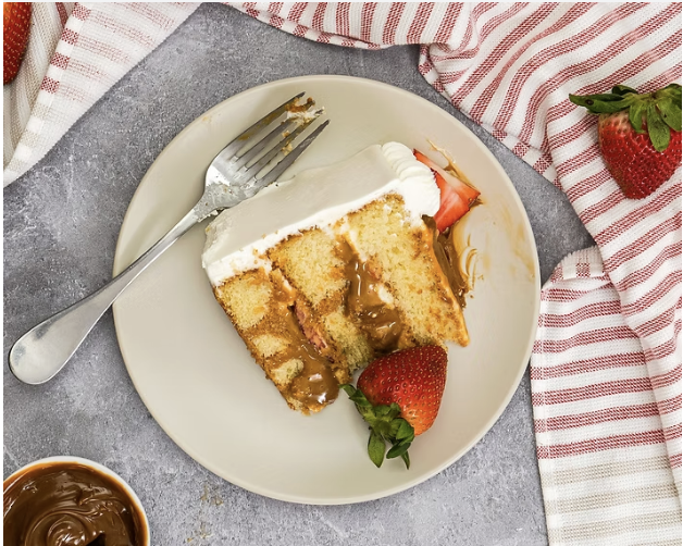 Sweet Fiesta Cakes quinceañera cake slice showing dulce de leche caramel filling between vanilla sponge layers