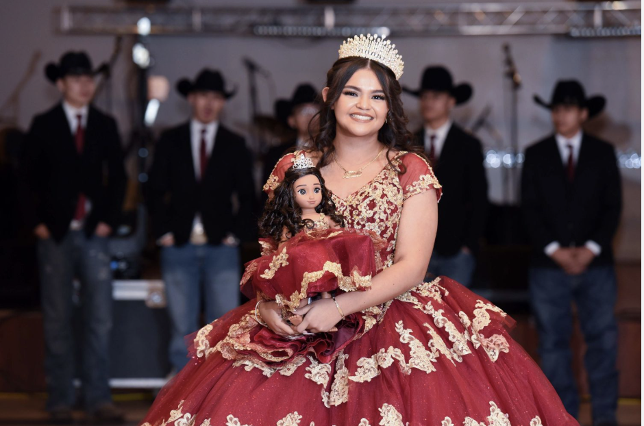  Quinceañera celebration with birthday girl in red gown holding her last doll at her quince party